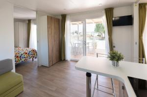 ein Wohnzimmer mit einem weißen Tisch und einem Balkon in der Unterkunft Mobile home Margherita Agricamping Spineta in Cortona