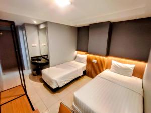 Habitación de hotel con 2 camas y lavamanos en Studio One Thamrin Hotel, en Yakarta