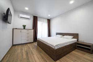 - une chambre avec un lit et une télévision dans l'établissement Weekend Family Hotel, à Karolino-Buhaz