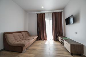- un salon avec un canapé et une télévision dans l'établissement Weekend Family Hotel, à Karolino-Buhaz
