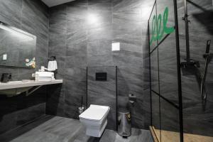 a bathroom with a toilet and a shower at Weekend Family Hotel in Karolino-Buhaz