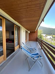 two chairs on the porch of a house at Apartment l’Alpette Oz en Oisans in Oz