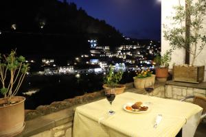 une table avec une assiette de nourriture et deux verres de vin dans l'établissement Margarita Guest House, à Berat