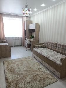 sala de estar con sofá y alfombra en Трёхкомнатная квартира ВИП, en Kokshetau