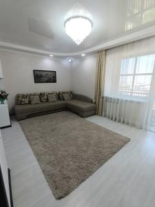 sala de estar con sofá y alfombra grande en Трёхкомнатная квартира ВИП, en Kokshetau