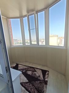 pusty pokój z 3 oknami i dywanem w obiekcie Трёхкомнатная квартира ВИП w mieście Kokczetaw
