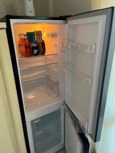 een open koelkast gevuld met drankjes en alcohol bij Feli Holiday Home - Panoramic pool lake view in Gardone Riviera in Gardone Riviera