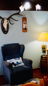 a living room with a blue chair and a deer head on the wall at Apartamentos Caloca in Caloca