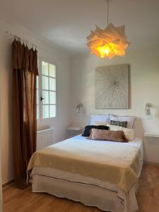 a bedroom with a large bed and a chandelier at Le Verger in Aix-en-Provence