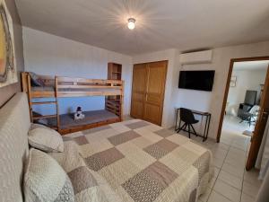 a bedroom with two bunk beds and a tv at Appart'O Soleil in Fréjus