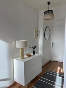 een wit dressoir met een lamp in een kamer bij Le Marengo in Toulouse