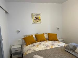 a bedroom with a bed with yellow pillows at Apartments Zahtila - Berto in Rabac