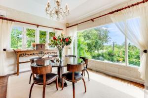 a dining room with a table and chairs and a large window at The Palms Resort in Saint James