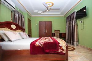 een slaapkamer met een bed met een rode deken bij Glory Hills Hotel in Kumasi
