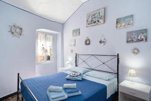 a bedroom with a blue bed with towels on it at Casa Acqua Mare Parasio in Imperia