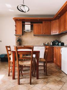 a kitchen with wooden cabinets and a table and chairs at Końska Dolina in Tylicz