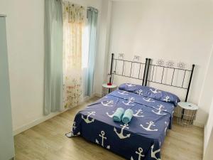 アリカンテにあるAlona Homeのベッドルーム1室(青い掛け布団、青い靴付)