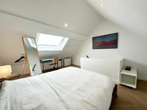a bedroom with a white bed and a window at Lovely ! Duplex de standing neuf – 250m des plages in Larmor-Plage