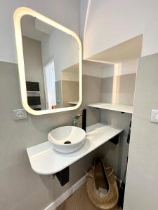 a bathroom with a white sink and a mirror at Lovely ! Duplex de standing neuf – 250m des plages in Larmor-Plage