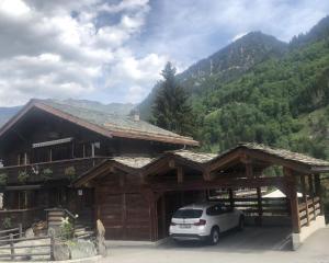a car parked in front of a wooden building at The cosy Isba - Chambre d hôtes - Val de Bagnes - Verbier in Versegeres 