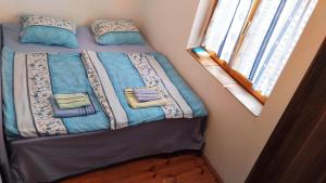 un letto con coperte blu e cuscini in una camera da letto di GuestHouse Zabljak a Žabljak