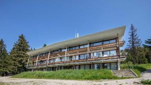 a building on a hill with trees in the background at V du Bachat - A21 Arolles - Appart spacieux 8pers in Chamrousse