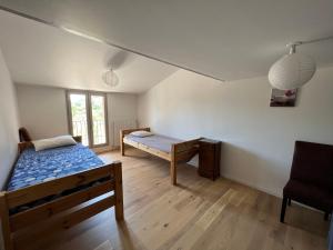 a room with two beds and a chair in it at Villa au lac du Salagou - 10 pers in Octon