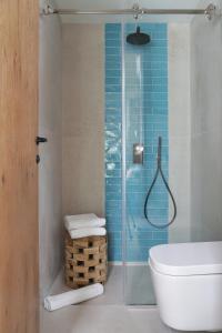 a bathroom with a toilet and a glass shower at Domes Noruz Chania, Autograph Collection- Adults Only in Kato Daratso
