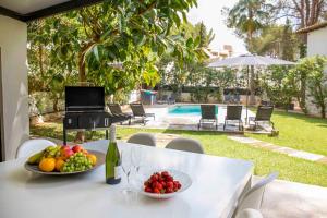 een tafel met twee fruitschalen en een fles wijn bij Villa Margarita in Palma de Mallorca