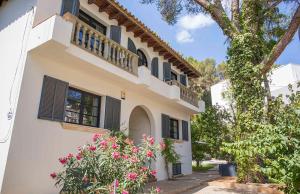 uma casa branca com janelas escuras e flores cor-de-rosa em Villa Margarita em Palma de Maiorca