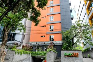un edificio naranja con un letrero delante de él en Studio One Thamrin Hotel, en Yakarta