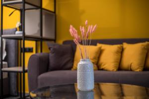 een vaas met roze bloemen op een glazen tafel bij GM Apartments-Rhodes Luxury Living in Kalithies