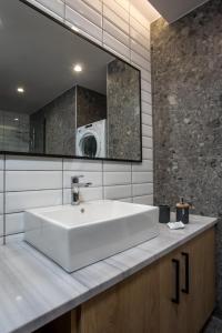een badkamer met een witte wastafel en een magnetron bij GM Apartments-Rhodes Luxury Living in Kalithies