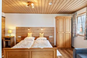 um quarto com uma cama grande e um tecto em madeira em Ferienwohnung Lengdobler - Leni em Bad Kohlgrub