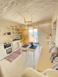 a kitchen and living room with a table and a couch at Traditional Syrma Nikos in Klima