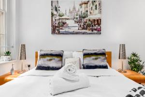 a bedroom with two beds and a painting on the wall at Luxurious 3-Bedroom Flat in London Sleeps 14 HY1 in London