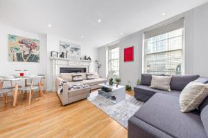 a living room with a couch and a table at Luxurious 3-Bedroom Flat in London Sleeps 14 HY1 in London