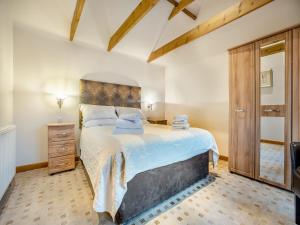 um quarto com uma cama grande e uma cabeceira em madeira em The Lodge - Uk44516 em North Thoresby