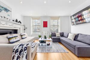a living room with two couches and a fireplace at Luxurious 3-Bedroom Flat in London Sleeps 14 HY1 in London