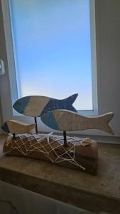 a wooden shark on a table in front of a window at Varandas de Luz in Armação de Pêra