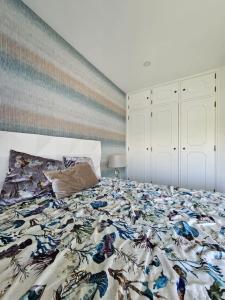 - une chambre avec un lit et une couverture colorée dans l'établissement Varandas de Luz, à Armação de Pêra