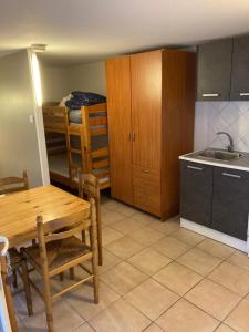 a kitchen with a table and a kitchen with a bunk bed at Studio Marseillan plage Robinson in Le Castellas
