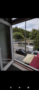 ein Fenster mit Blick auf einen Parkplatz mit Auto in der Unterkunft Valentim House in Viana do Castelo