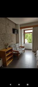 Cette chambre comprend un lit, une table et une fenêtre. dans l'établissement Valentim House, à Viana do Castelo