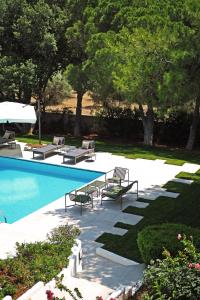 a swimming pool with lounge chairs and a table at Villa Oasis with Large Pool Athenian Riviera Lagonissi in Lagonissi