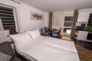 una camera da letto con un letto bianco, un tavolo e delle sedie di CityWohnungFN a Friedrichshafen