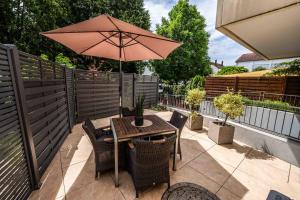 un tavolo e sedie con un ombrellone in un patio di CityWohnungFN a Friedrichshafen