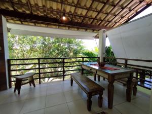 um alpendre com uma mesa, um banco e uma varanda em Reserva Imbassaí Apartamento 1 quarto área de churrasco Bl2202 em Mata de São João