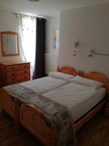 a bedroom with a bed and a dresser and a window at Appartamenti Acidule in Bagni di Rabbi