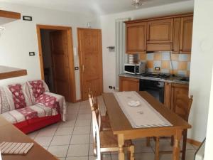 a kitchen and living room with a table and a couch at Appartamenti Acidule in Bagni di Rabbi